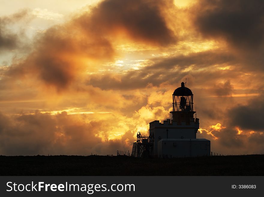 Birsay Lighthouse, Orkney, in silhouette at sunset. Birsay Lighthouse, Orkney, in silhouette at sunset