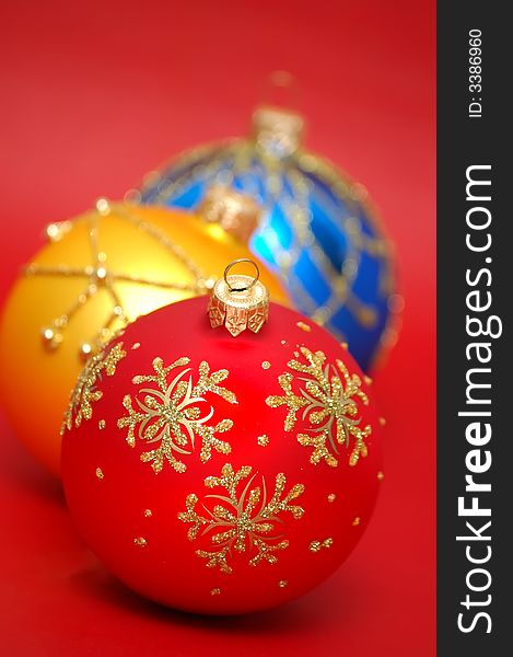 Three colorful christmas balls on a red background