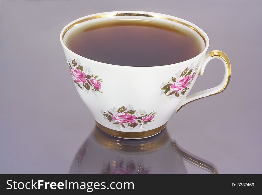 Full white china cup of tea with reflection