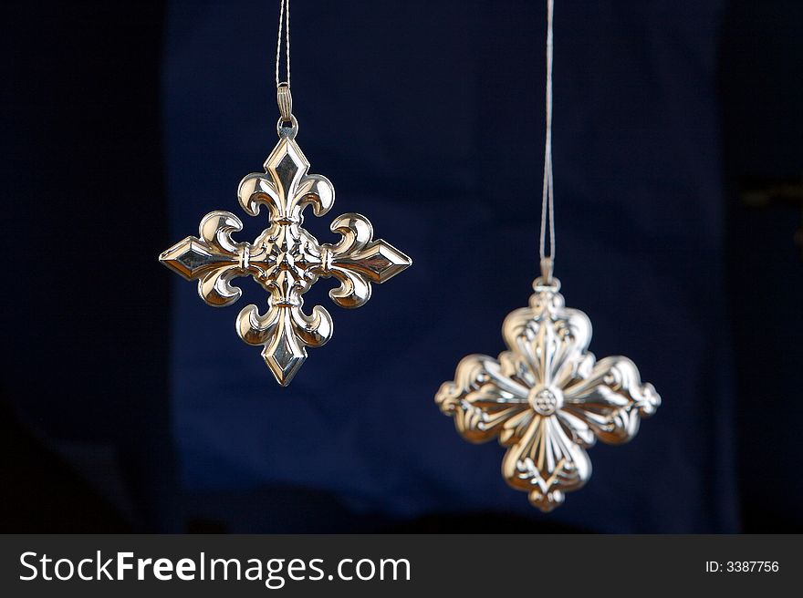 Silver crosses Christmas decorations isolated on blue/black background
