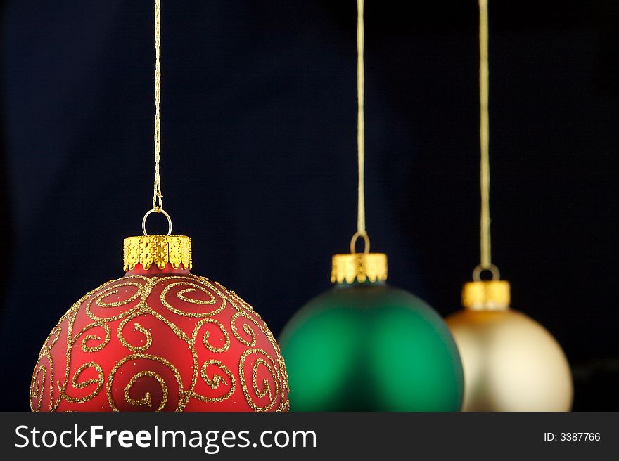 Red, green and gold Christmas decorations isolated on blue/black background