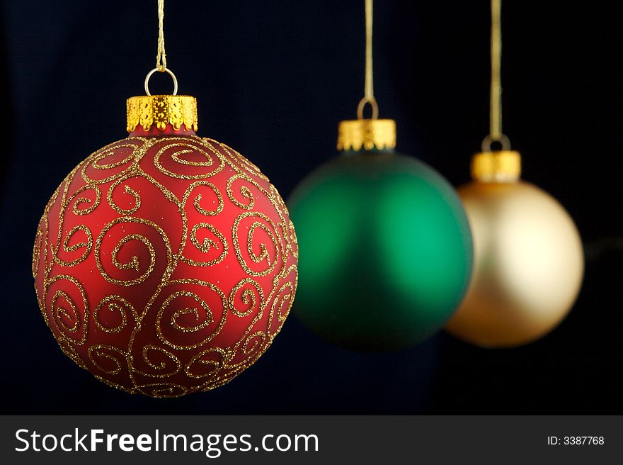 Red, green and gold Christmas decorations isolated on blue/black background