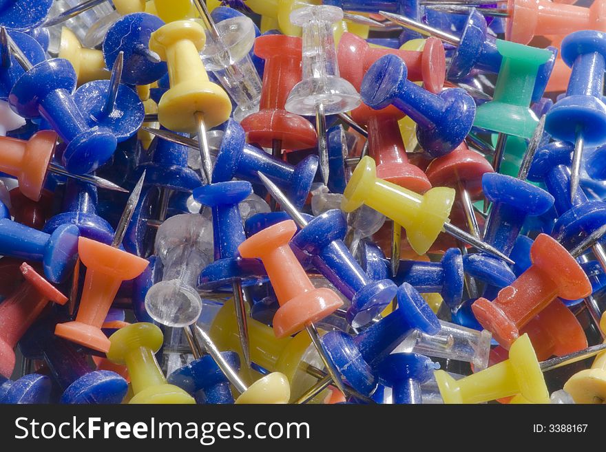 A closeup of a pile of colorful push pins.