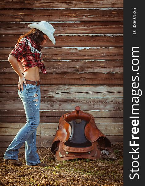 Young adult woman wearing country style posing on farmland. Young adult woman wearing country style posing on farmland