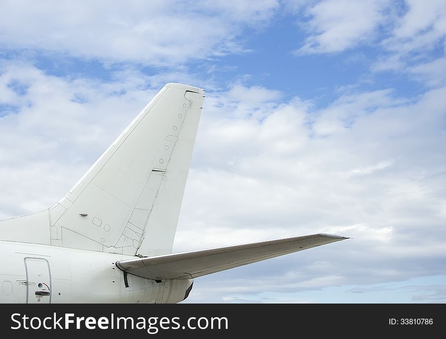 Crop of the airplane back wing on the sky background