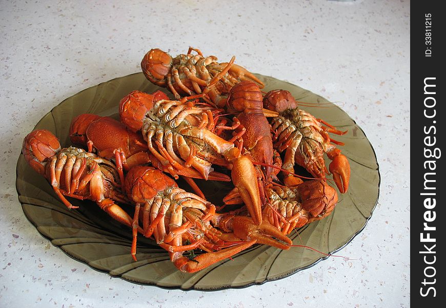 вoiled crawfish are in a plate on white table. вoiled crawfish are in a plate on white table