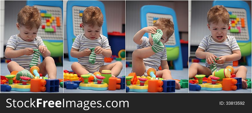 A funny baby boy trying to dress socks in children's room