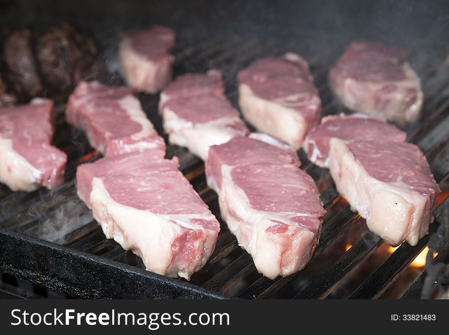 Beef steak raw on an open flame grill