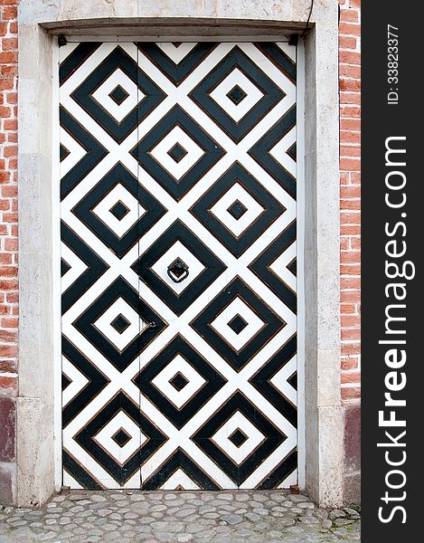 Door into a brick wall with white and black squares ornament