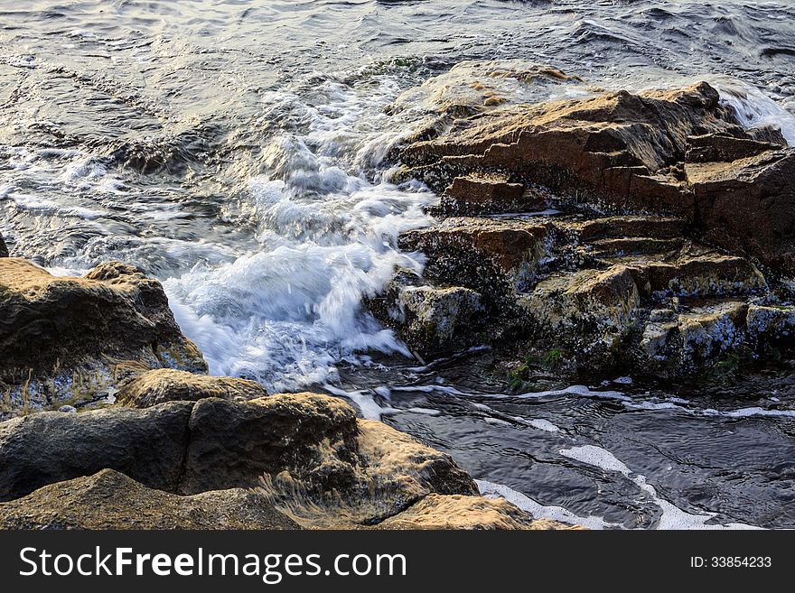 Sea â€‹â€‹wave attacks the boulders and is broken about them. Sea â€‹â€‹wave attacks the boulders and is broken about them