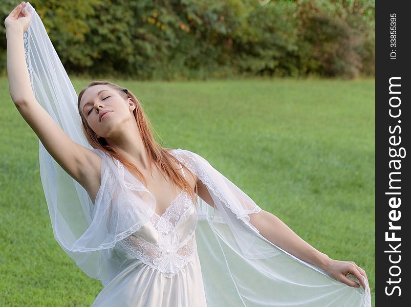 An image of a blissful woman outside in a peignoir. An image of a blissful woman outside in a peignoir