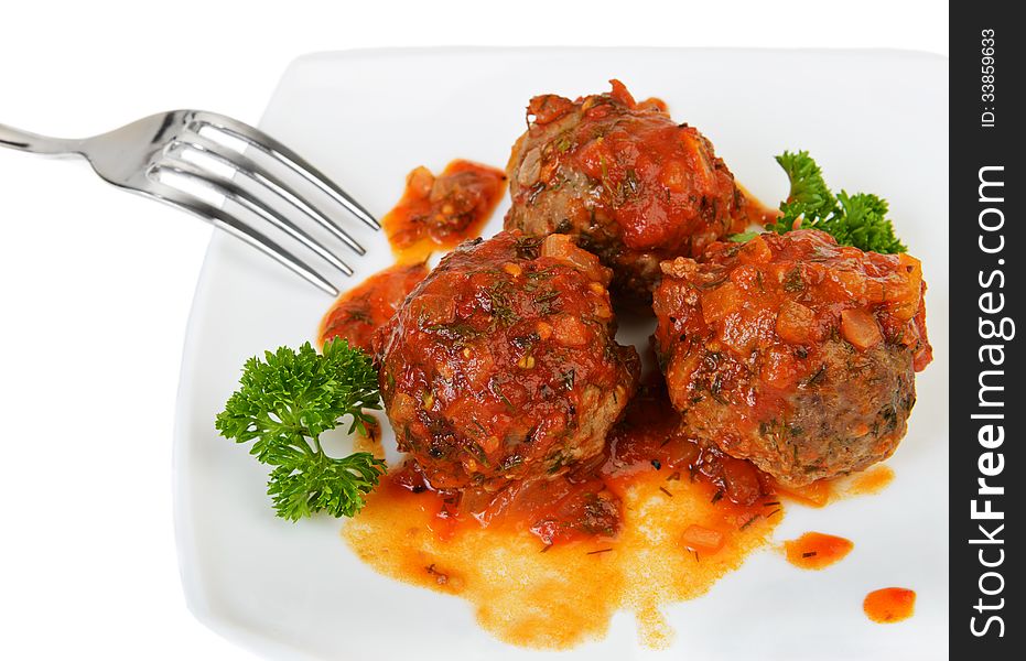 Meatballs on plate over white with fork