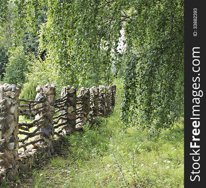 The old fence is made of a stone and a tree. The old fence is made of a stone and a tree.