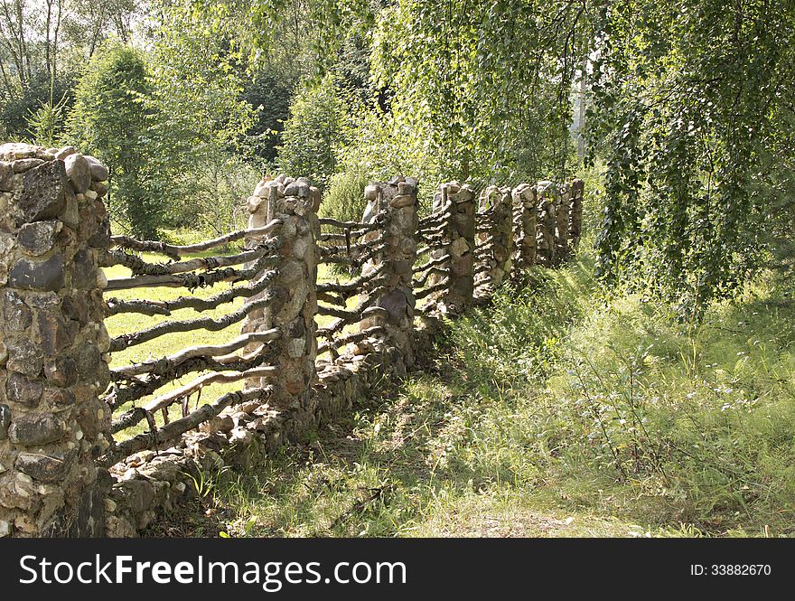 The old fence is made of a stone and a tree. The old fence is made of a stone and a tree.