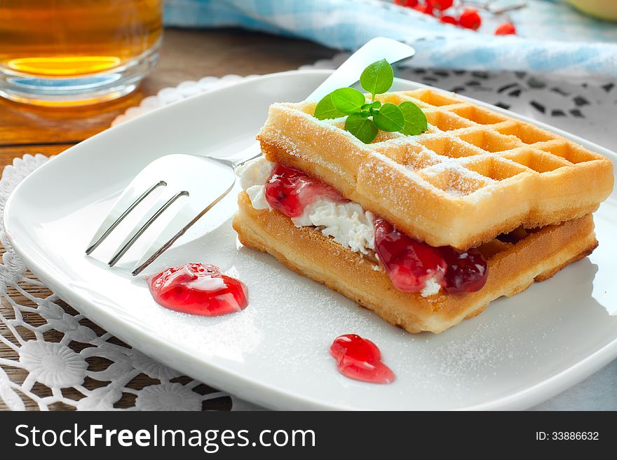 Waffles with jam and cream on a white plate , dessert. Waffles with jam and cream on a white plate , dessert