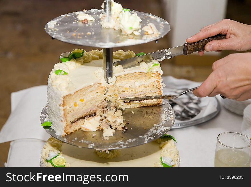 A woman cutting cake on wedding party. A woman cutting cake on wedding party