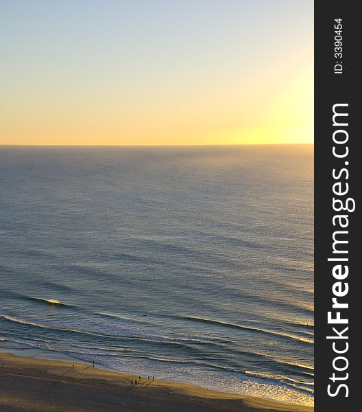 Aerial View of sun rise over beach, distant people, distant waves, in Queensland Australia. Aerial View of sun rise over beach, distant people, distant waves, in Queensland Australia