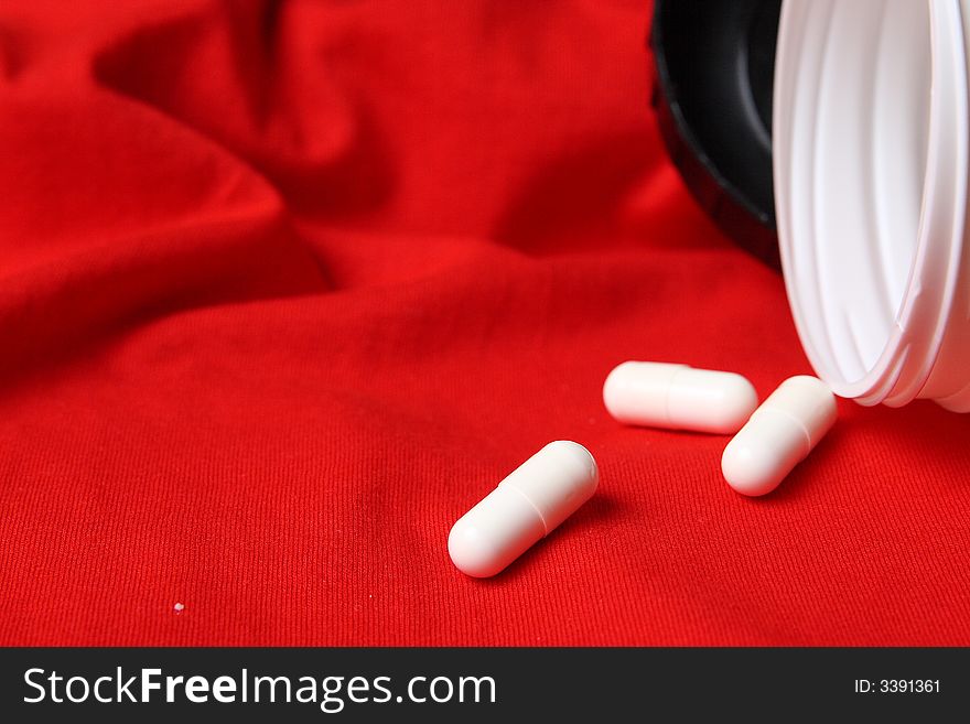White Pills And Red Background
