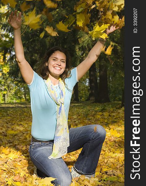 Beautiful woman in blue shirt with yellow maple leaves. Beautiful woman in blue shirt with yellow maple leaves