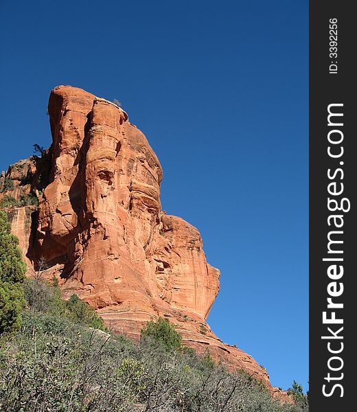 Red rocks of Sedona rise out of the low trees and scrub. Red rocks of Sedona rise out of the low trees and scrub