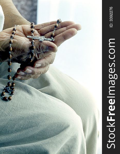 Hands holding rosary in meditation.
