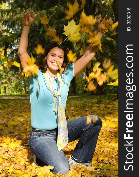 Beautiful woman in blue shirt with yellow maple leaves. Beautiful woman in blue shirt with yellow maple leaves