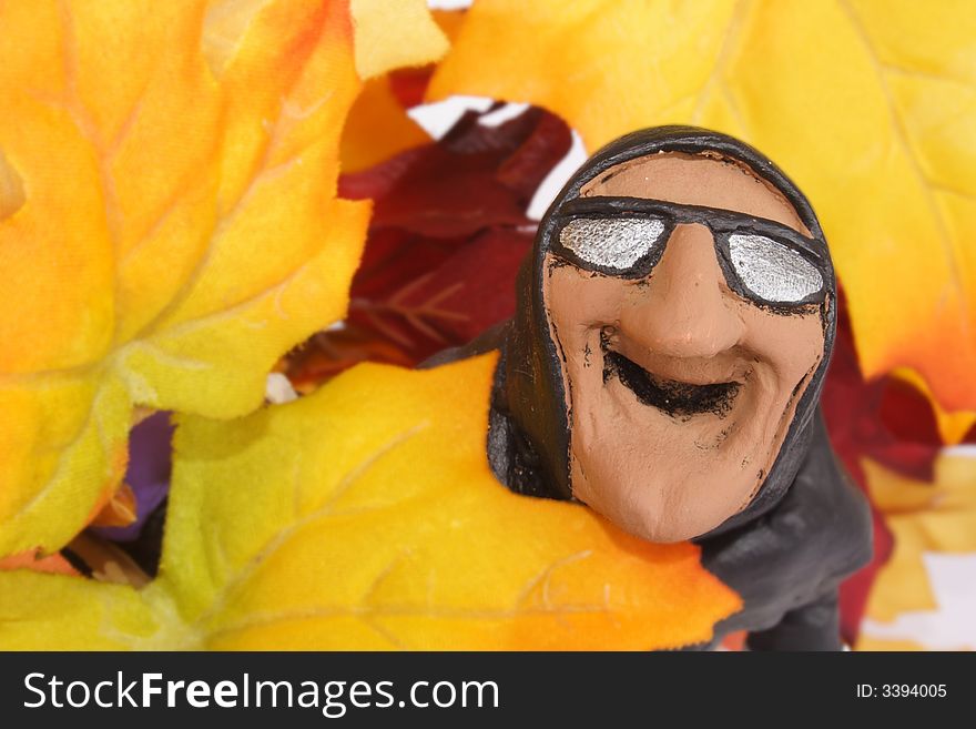 Head of laughing witch among autumn leaves. Head of laughing witch among autumn leaves