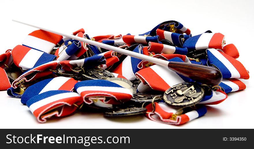 A conductor's baton on top of many music medals. A conductor's baton on top of many music medals.