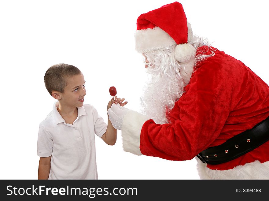 Adorable little boy getting a treat from Santa Claus. Isolated on white. Adorable little boy getting a treat from Santa Claus. Isolated on white.