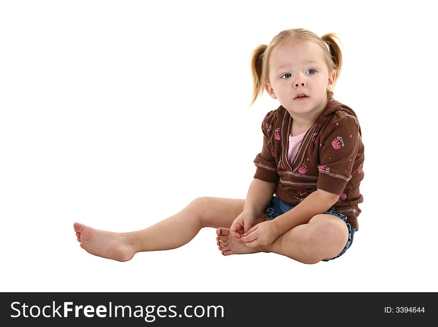 Adorable 2 year old girl sitting barefoot over white. Adorable 2 year old girl sitting barefoot over white.