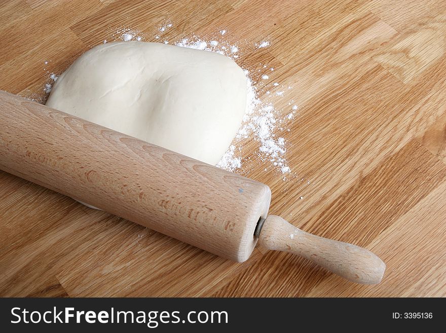 Bread dough on wooden kitchen counter with rolling pin. Bread dough on wooden kitchen counter with rolling pin