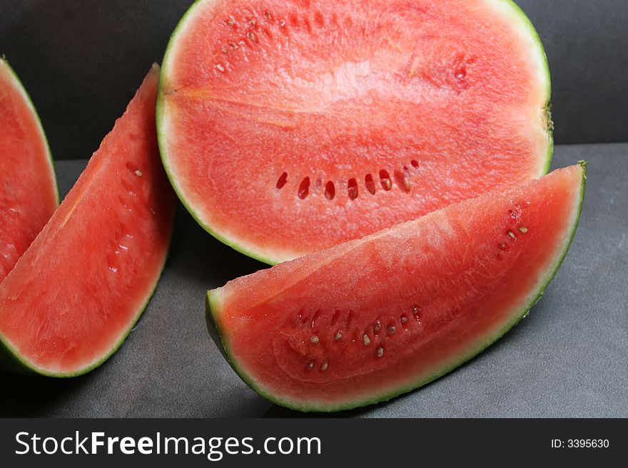 Cut watermelon on a dark grey background. Cut watermelon on a dark grey background