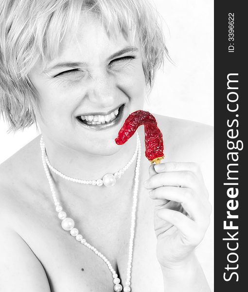 The cheerful blonde holds a pod of hot pepper. The cheerful blonde holds a pod of hot pepper