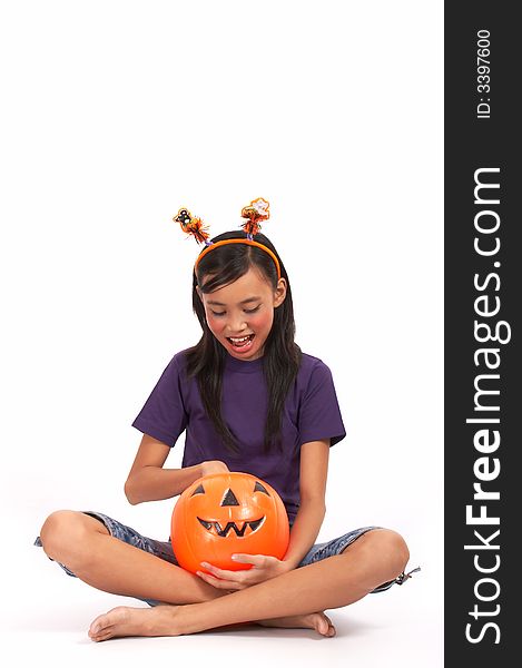 A happy girl holding a pumpkin over a white background