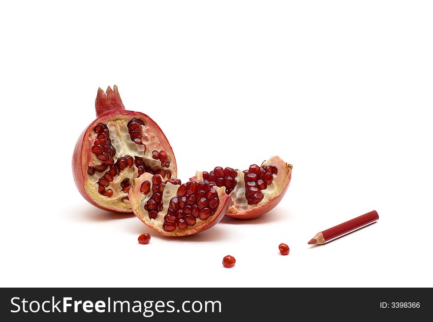 Broken pomegranate with grains and red pencil