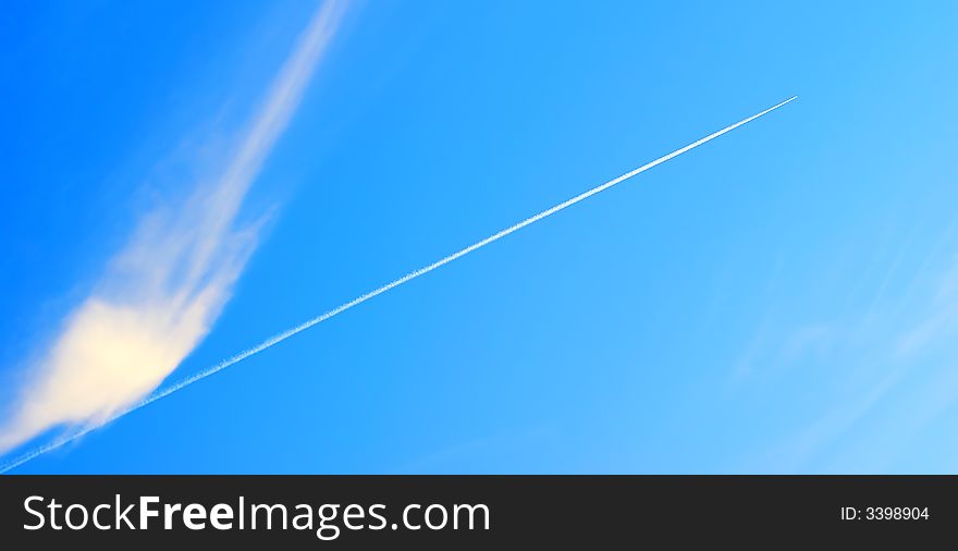 The jet military plane gains height, on a background of the blue sky. The form of easy clouds emphasizes effect of speed. The jet military plane gains height, on a background of the blue sky. The form of easy clouds emphasizes effect of speed.
