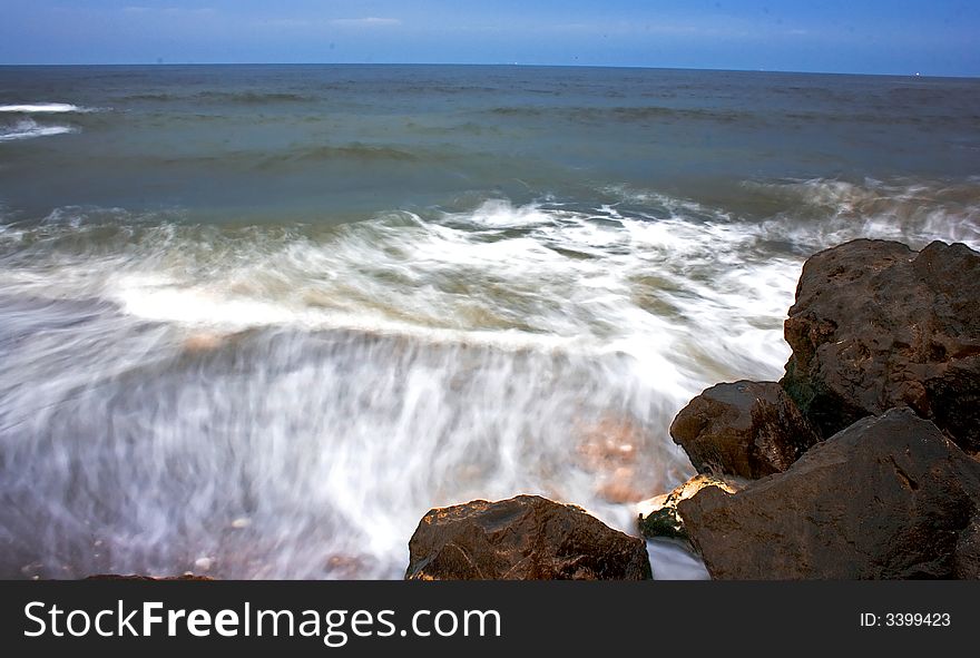 Landscape with rocks and blue sea in the evening