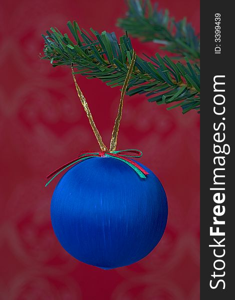 Blue christmas ball hanging isolated on red background