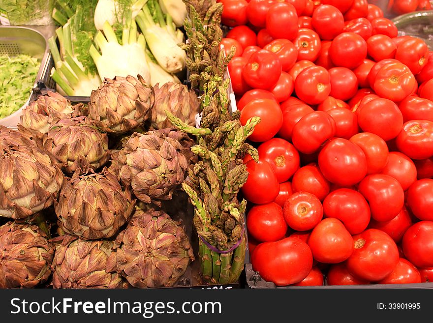 Artichokes and tomatoes separated by a layer of asparagus and in the far salads.