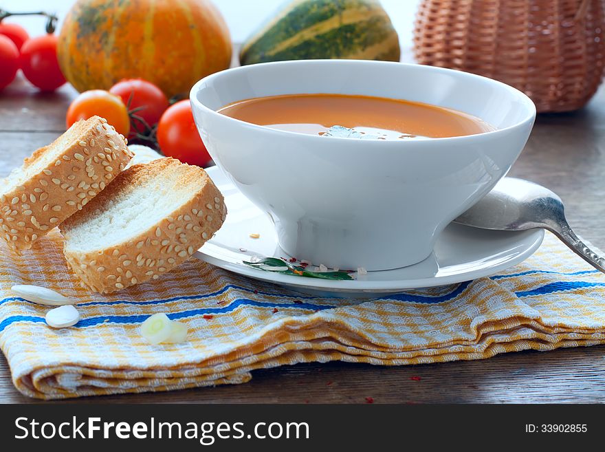 pumpkin soup with toasts, lunch with vegetables in the background