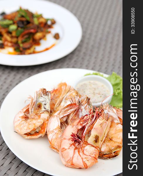 Grilled shrimps with seafood sauce on white plate