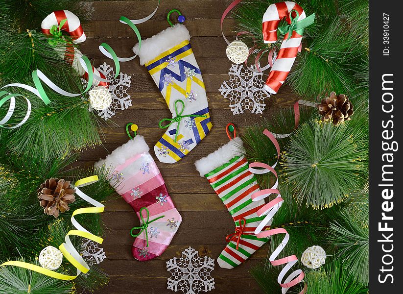 Three Christmas socking with candy sticks and decorations on wooden background. Three Christmas socking with candy sticks and decorations on wooden background