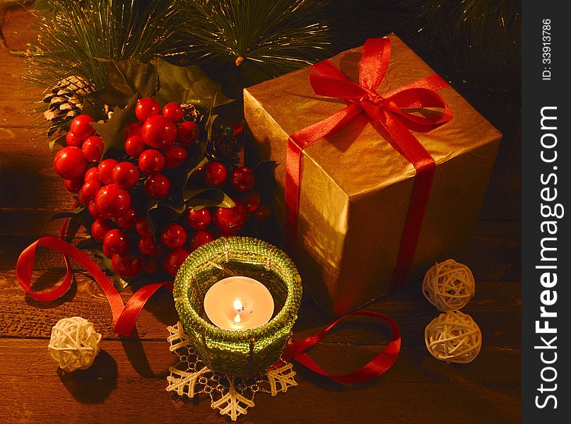 Golden box with burning green candle and ilex. Golden box with burning green candle and ilex