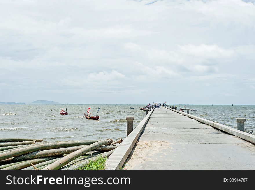 Old jetty at the beach with boat