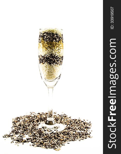 Colored grain in a glass of champagne isolated on white background