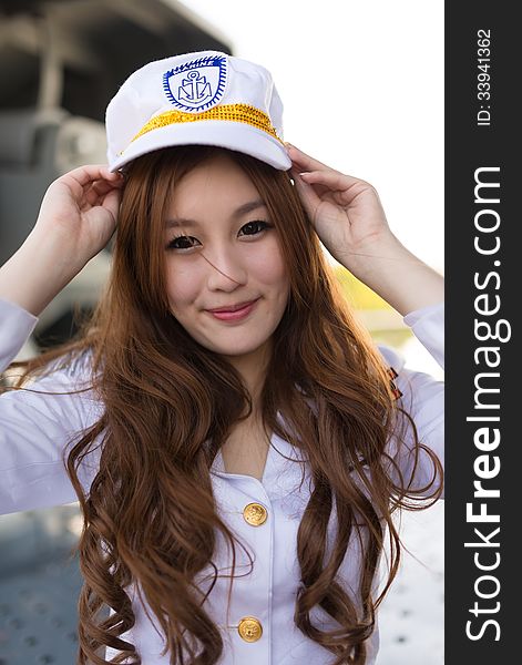 Pretty woman sailor grabing marine hat expression on battleship