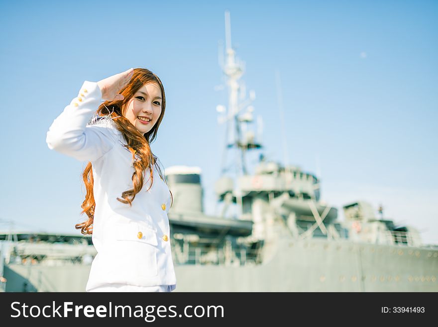 Woman sailor salute expression with battleship background