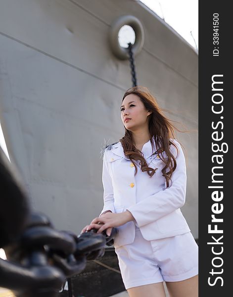 Woman sailor standing against ship anchor's chain