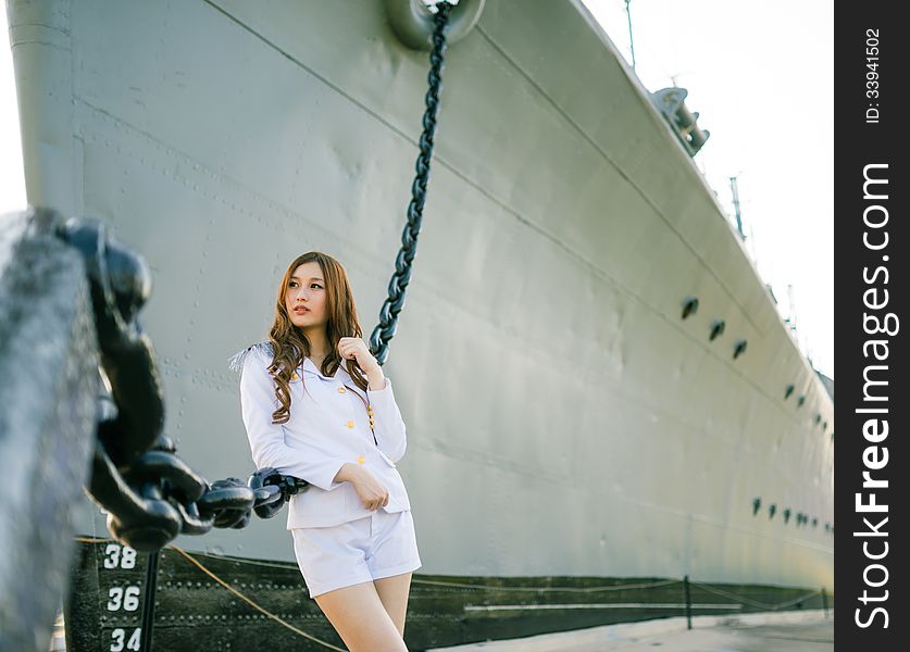 Woman sailor standing against ship anchor's chain