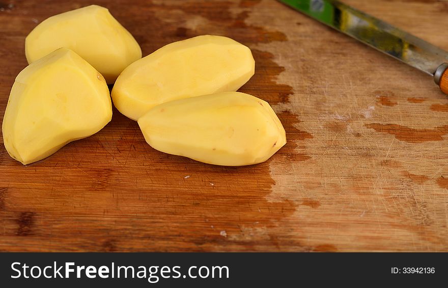 This is an image of 4 small potatoes on a cutting board. This is an image of 4 small potatoes on a cutting board.